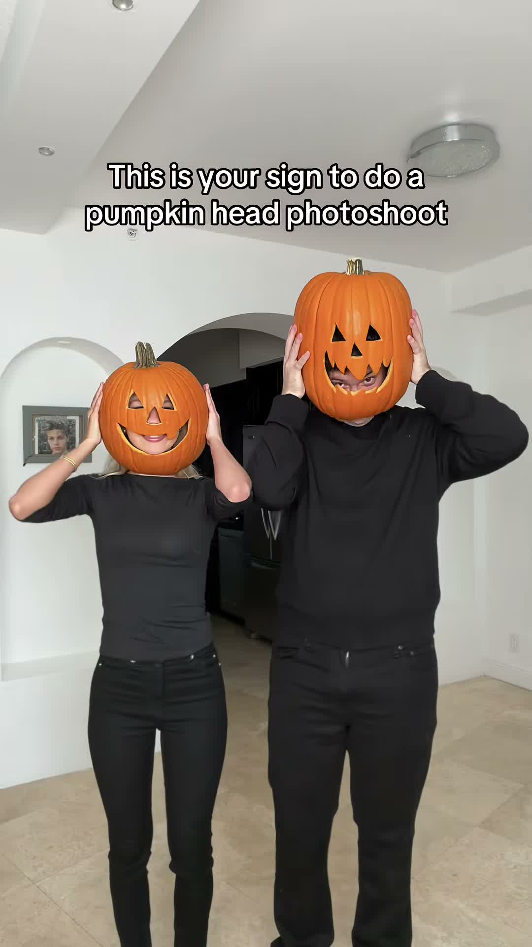 Person with a carved pumpkin head standing in a field at dusk, TikTok trend clip
